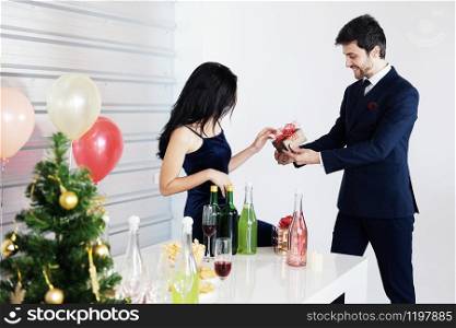 Sweet couple Love happy with surprise gift box girlfriend in christmas time and celebrating new year eve, Valentine day decoration with Christmas tree, colorful balloon and Gift Boxes in pantry Area