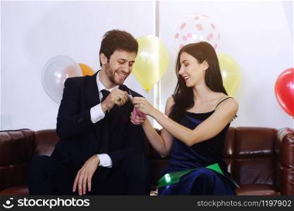 Sweet couple Love smile and spending Romantic christmas time and celebrating new year eve, birthday, and valentine on Brown Sofa decoration with colorful balloon and Gift Boxes in Living room at home
