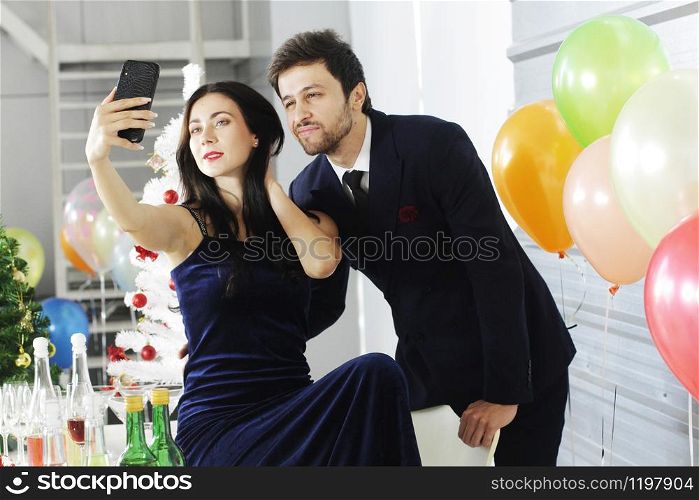 Sweet couple Love smile and spending Romantic for Take a picture with a mobile phone in christmas time and celebrating new year eve, valentine day with colorful balloons in pantry area.