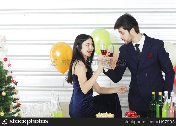 Sweet couple Love smile and spending Romantic with drinking wine in christmas time and celebrating new year eve, valentine day with colorful balloon and Gift Boxes at pantry area