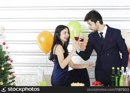 Sweet couple Love smile and spending Romantic with drinking wine in christmas time and celebrating new year eve, valentine day with colorful balloon and Gift Boxes at pantry area