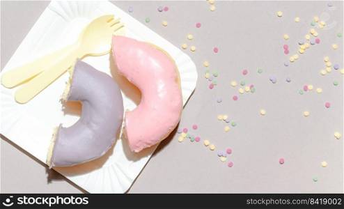 Sweet dessert concept, Colorful pastel donuts in white plate with cutlery on grey background.