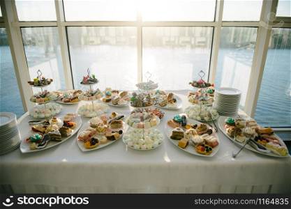 Sweet dessert table at a wedding.Cakestand at a wedding day. Sweet dessert table at a wedding.Cakestand at a wedding