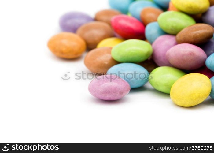 sweet dragees of different color on white background