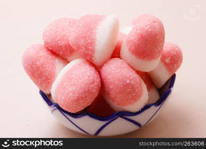 Sweet food candy. Pink jellies or marshmallows with sugar in bowl on wooden table