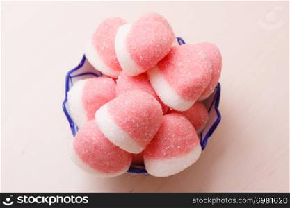 Sweet food candy. Pink jellies or marshmallows with sugar in bowl on wooden table