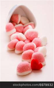 Sweet food candy. Pink jellies or marshmallows with sugar in white bowl on wooden table decorated with red heart love symbol