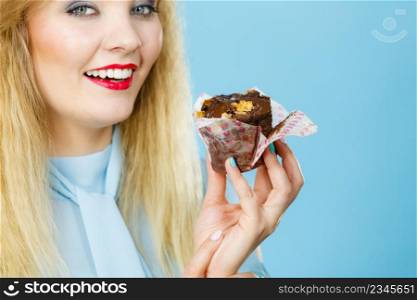 Sweet food sugar make us happy. Attractive blonde woman holds yummy chocolate cupcake in hand, craving for cake. Appetite and tasty meal dessert.. Attractive woman holds cake in hand