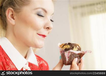 Sweet food sugar make us happy. Attractive blonde woman holds yummy chocolate cupcake in hand, craving for cake.. Attractive woman holds cake in hand