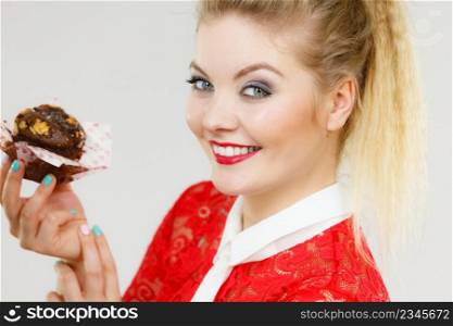 Sweet food sugar make us happy. Attractive blonde woman holds yummy chocolate cupcake in hand.. Attractive woman holds cake in hand