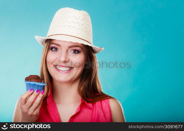 Sweet food sugar make us happy. Smiling woman summer clothing holds cake chocolate muffin in hand blue background