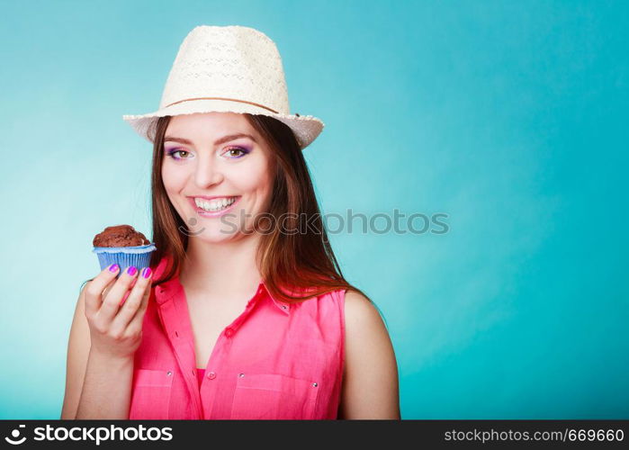 Sweet food sugar make us happy. Smiling woman summer clothing holds cake chocolate muffin in hand blue background