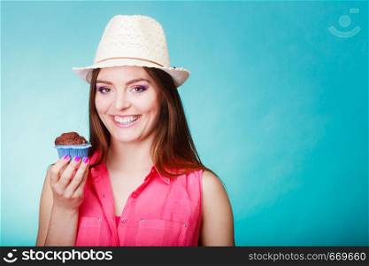 Sweet food sugar make us happy. Smiling woman summer clothing holds cake chocolate muffin in hand blue background