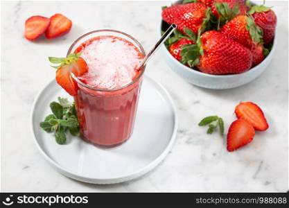 Sweet fresh strawberry juice on marble table. Healthy food