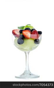 sweet fruits in glass. Fresh forest berries and melon in a glass on a white background