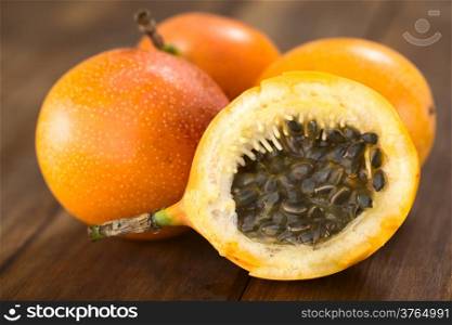 Sweet granadilla or grenadia (lat. Passiflora ligularis) cut in half, of which the seeds and the surrounding juicy pulp is eaten or is used to prepare juice (Selective Focus, Focus on the front of the seeds)
