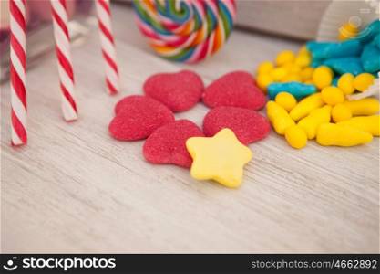 Sweet hearts shaped and other candies on wooden grey background. Soft Focus.