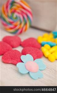 Sweet hearts shaped and other candies on wooden grey background. Soft Focus.