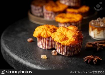 Sweet homemade cottage cheese muffins with pumpkin on dark wooden background. Sweet cottage cheese muffins