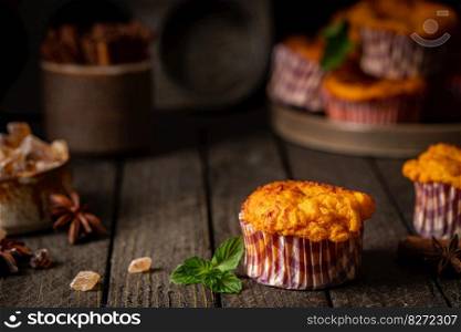 Sweet homemade cottage cheese muffins with pumpkin on dark wooden background. Sweet cottage cheese muffins