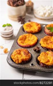 Sweet homemade cottage cheese muffins with pumpkin on white background. Sweet cottage cheese muffins