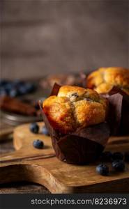 Sweet homemade pastries muffin with blueberries and fresh berries on wooden background.. homemade muffin with blueberries