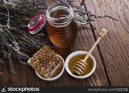 Sweet honey in the comb, glass jar. Jar full of fresh honey and honeycombs