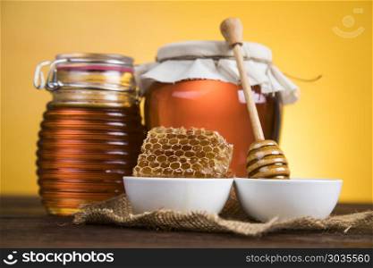 Sweet honey in the comb, glass jar. Jar full of fresh honey and honeycombs