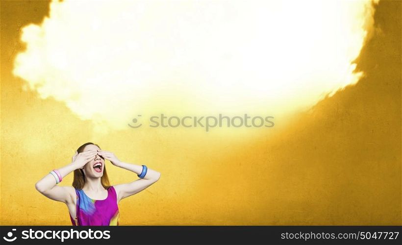 Sweet life. Young girl in multicolored dress closing eyes with palms