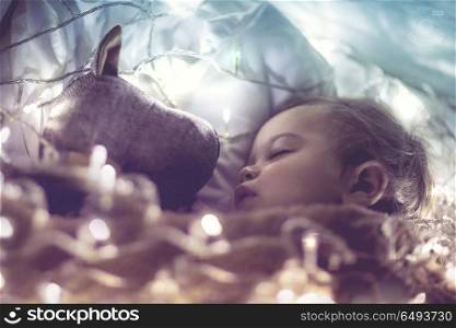 Sweet little baby boy sleeping with favourite soft toy, dreaming at home on magic night, vintage style fantasy photo. Sweet baby sleeping with soft toy