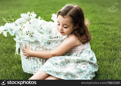Sweet little girl holding a basket full of flowers