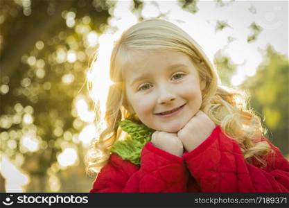 Sweet Little Girl Wearing Winter Coat and Scarf Outdoors at the Park.