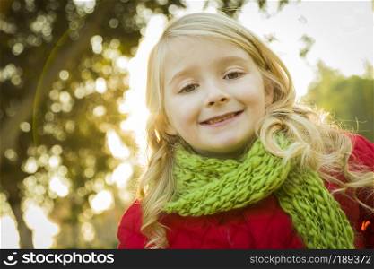 Sweet Little Girl Wearing Winter Coat and Scarf Outdoors at the Park.