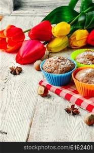 Sweet muffin tins and bouquet of fresh cut tulips. Sweet cupcake dessert