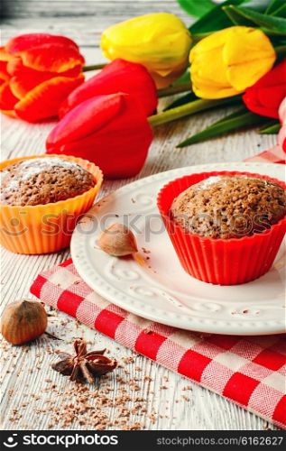 Sweet muffin tins and bouquet of fresh cut tulips. Sweet cupcake dessert