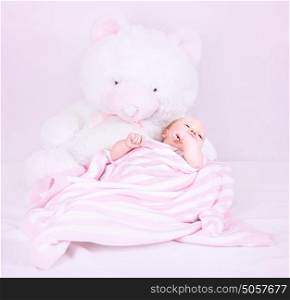 Sweet newborn girl lying down in cute pink bedroom near big white fluffy teddy bear, happy childhood, love concept