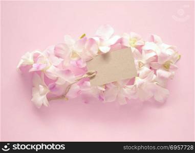 Sweet orchids bouquet with a blank gift tag for valentines or anniversary message on pink background.. Orchids bouquetwith tag on pink background.