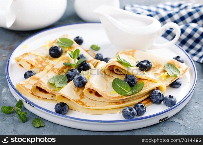 Sweet pancakes wrapped with fresh berries, crepes with blueberry