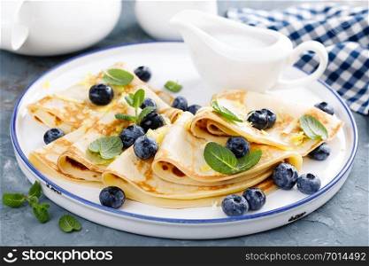 Sweet pancakes wrapped with fresh berries, crepes with blueberry