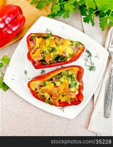 Sweet pepper stuffed with sausage, egg and cheese with fennel in the plate, napkin, fork and parsley on of the table background top