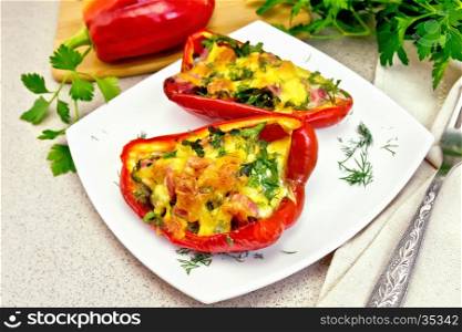 Sweet pepper stuffed with sausage, egg and cheese with fennel in the plate, napkin, fork and parsley on a background of a granite table