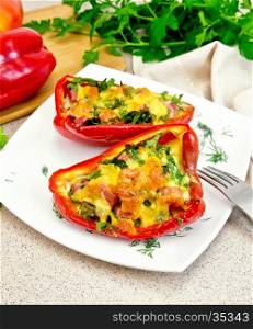 Sweet pepper stuffed with sausage, egg with fennel in the plate, napkin, fork and parsley on table background