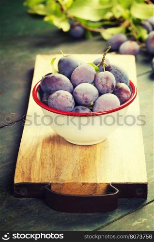 Sweet plums on wooden background.Bio healthy fruits. Selective focus. Copy space background