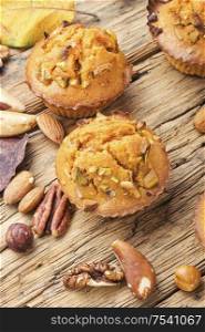 Sweet pumpkin muffins with nuts.Autumn food.Cupcake on old wooden table. Homemade pumpkin muffins