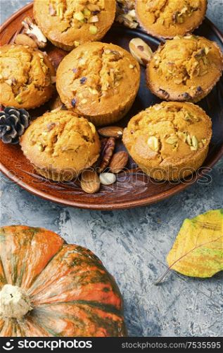 Sweet pumpkin muffins with nuts.Autumn food.Cupcake on plate. Autumn pumpkin muffins