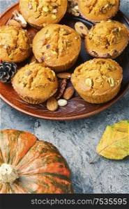 Sweet pumpkin muffins with nuts.Autumn food.Cupcake on plate. Autumn pumpkin muffins