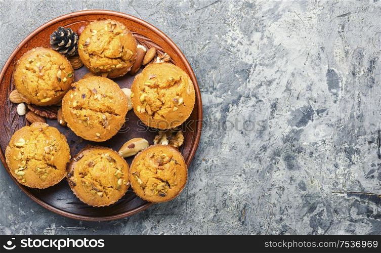 Sweet pumpkin muffins with nuts.Autumn food.Cupcake on plate. Homemade delicious pumpkin muffin