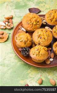 Sweet pumpkin muffins with nuts.Autumn food.Cupcake on plate. Homemade pumpkin muffins
