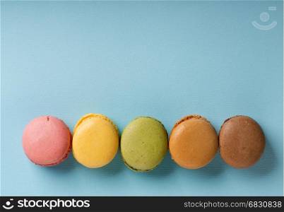 Sweet round macarons on a blue background