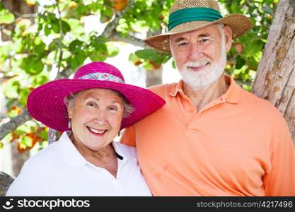 Sweet senior couple wearing their sun hats on vacation.
